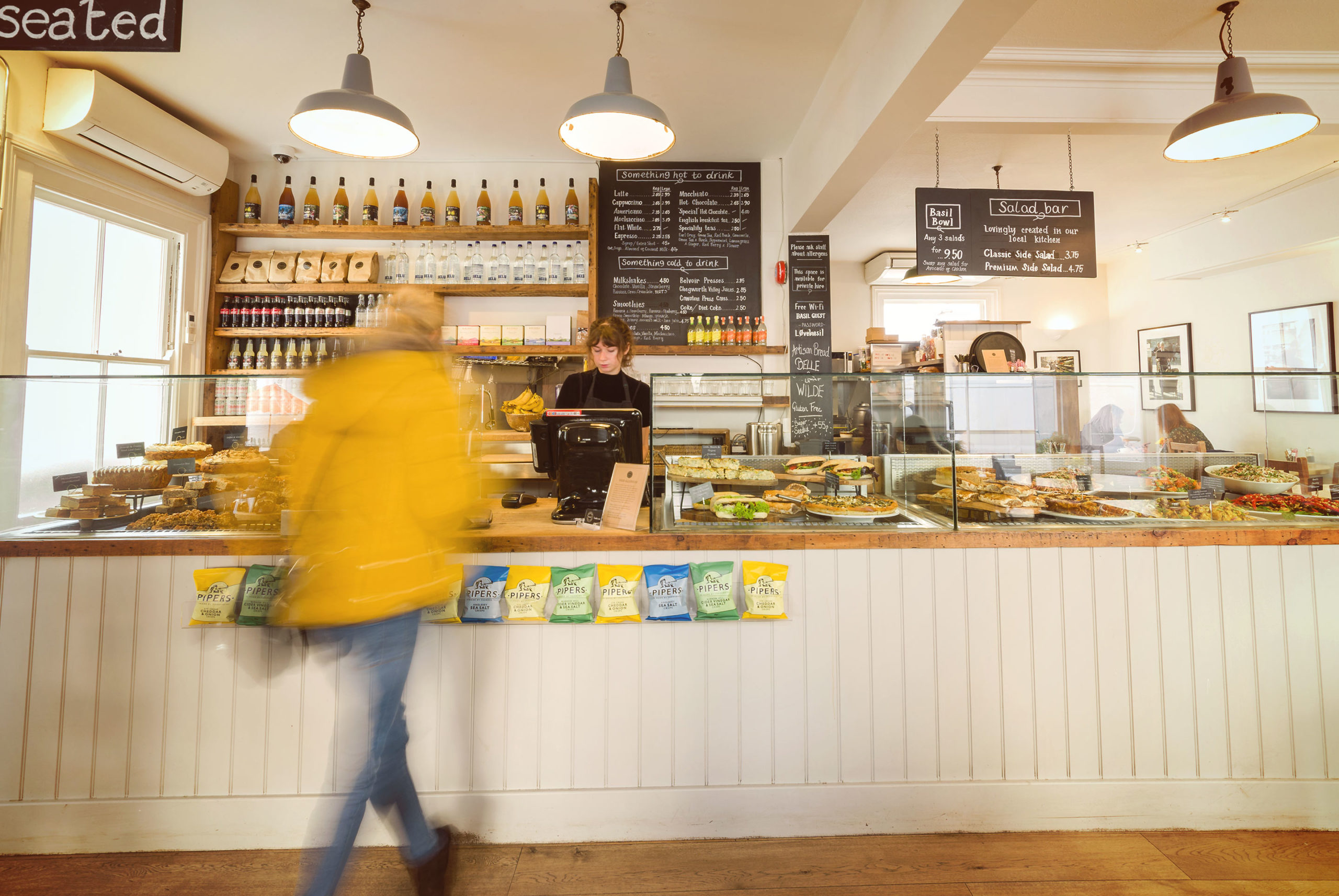 Inside Basil Wholefoods cafe with barista and customer